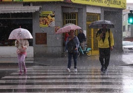 Viandantes con paraguas en Pajarillos durante el aguacero del pasado viernes.