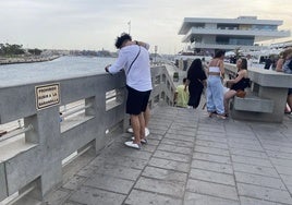 Carteles informativos que advierten de que no se permite sentarse en el muro, en la Marina.