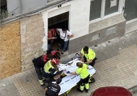 El hombre, entre bomberos, personal sanitario y policías, tras ser rescatado.